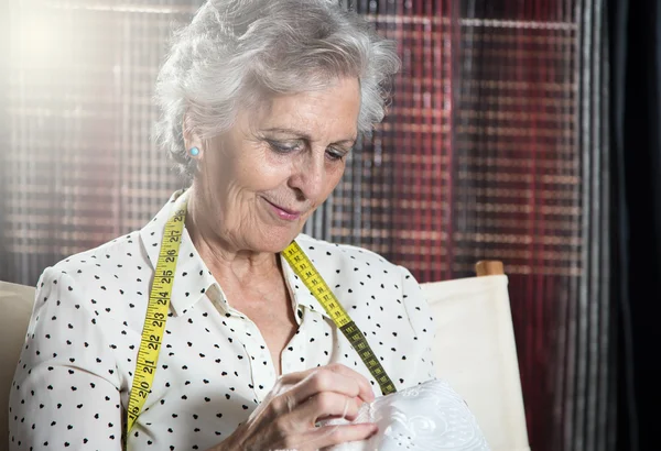 Портрет счастливой пожилой женщины, шьющей — стоковое фото