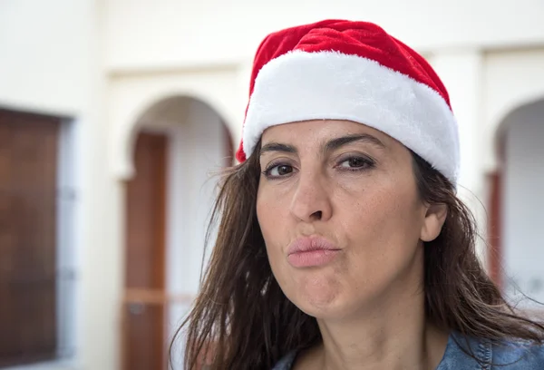 Mulher morena com chapéu de Natal vermelho sorrindo — Fotografia de Stock