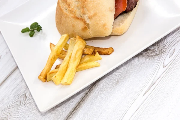 Burger with cheese, tomato, lettuce and chips — Stock Photo, Image