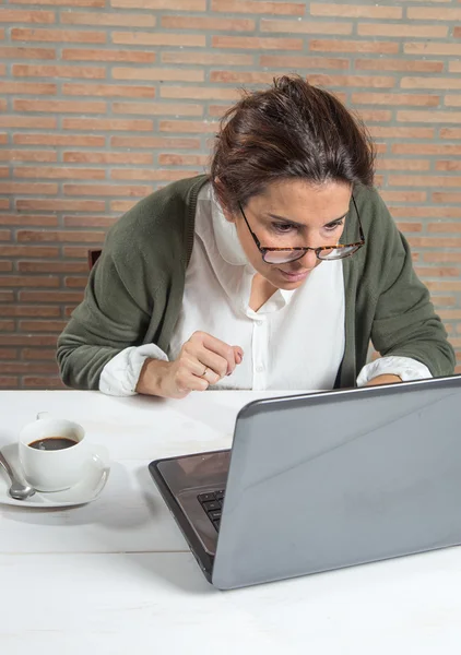 Vrouw achter laptop met koffiekopje — Stockfoto