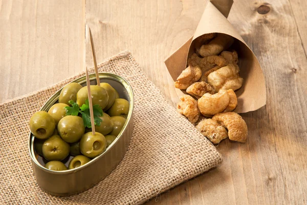 Cap and olives pork rinds — Stock Photo, Image