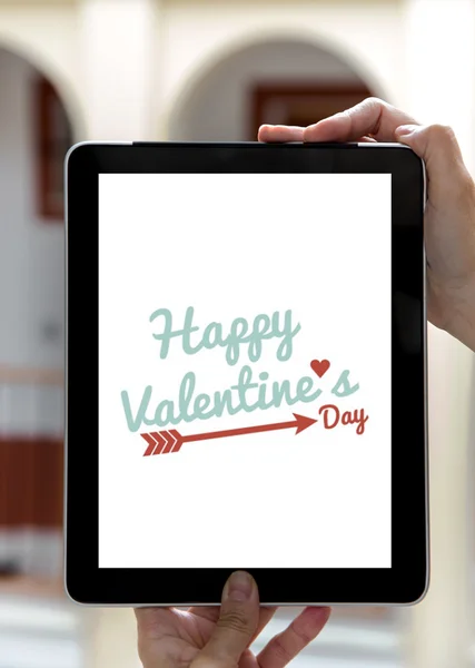 Manos sosteniendo la tableta con el signo de San Valentín día —  Fotos de Stock