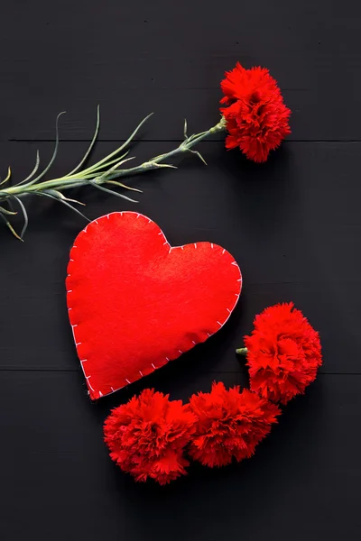 Still life of red carnations and handmade heart — Stock Photo, Image