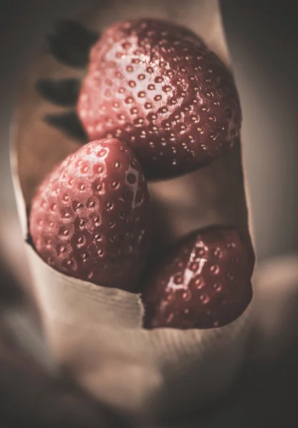 Μεγέθυνση του χέρι που κρατά νόστιμα φράουλες — Φωτογραφία Αρχείου
