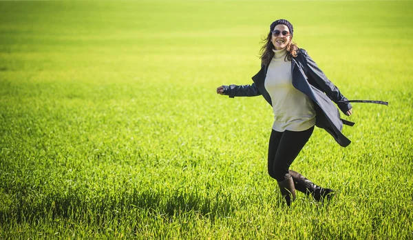 Donna con zaino a piedi in campo verde — Foto Stock