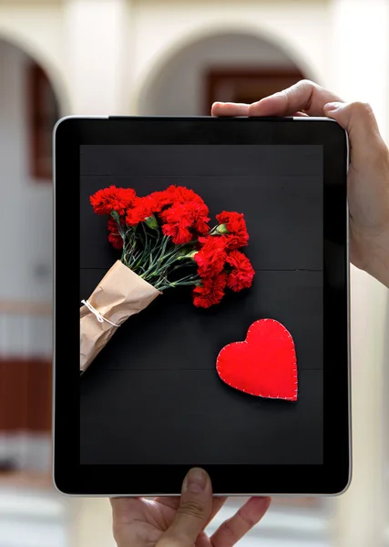 Mains tenant la tablette avec des photos Saint Valentin — Photo