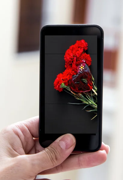 손을 잡고 빨간 카네이션의 꽃다발의 이미지와 스마트폰 — 스톡 사진