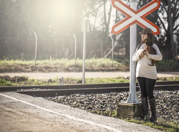 Mulher caminhando ao longo da estrada de ferro com cão — Fotografia de Stock