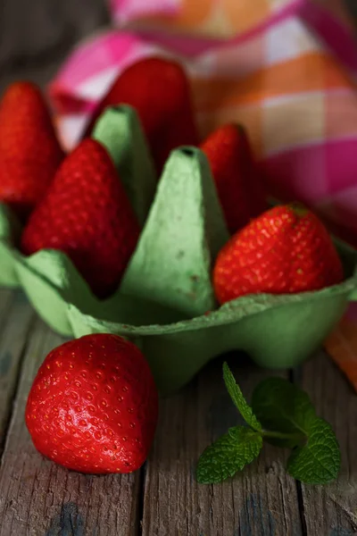 Erdbeeren mit Minze auf altem Holztisch — Stockfoto