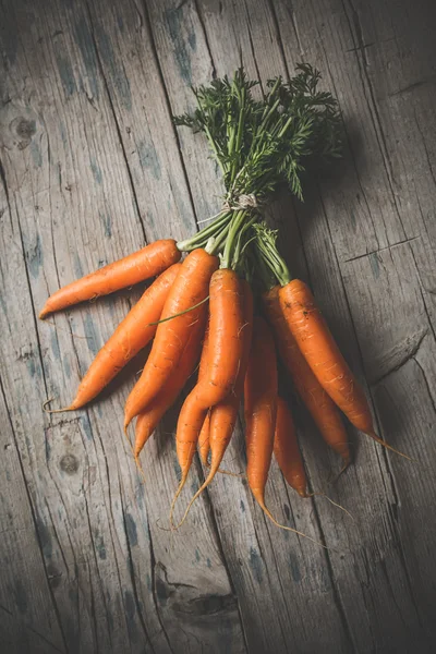 Морковь кучу на деревянном фоне — стоковое фото