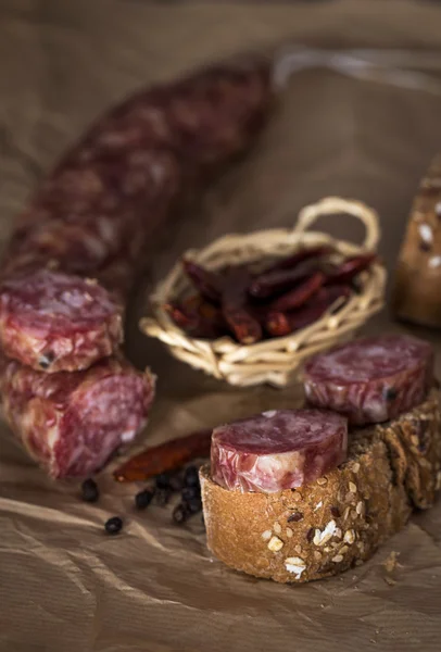 Pezzi di salsiccia con pane su carta — Foto Stock