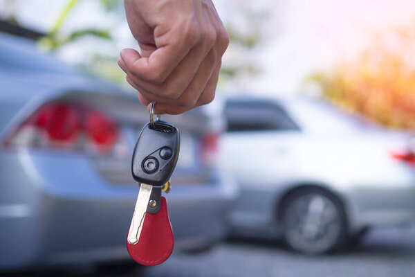 The car salesman and the key to the new owner.   