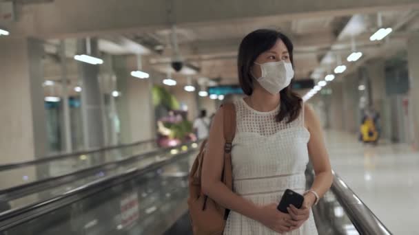 女性は空港セットで飛行機に乗っているすべての摩耗マスクは 病気を収縮するリスクを減らすために 飛行機で旅行する女性が飛行機に乗るための門を探しています — ストック動画