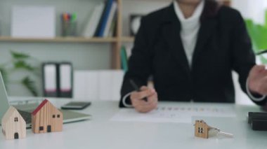 Ev sigortası komisyoncusu ya da satıcı elinde yeni ev sahibine verilmiş bir ev anahtarı tutuyor. Ajans, sözleşme imzalamadan önce belgeleri tekrar kontrol etti. Emlak ve emlak konsepti satmak.