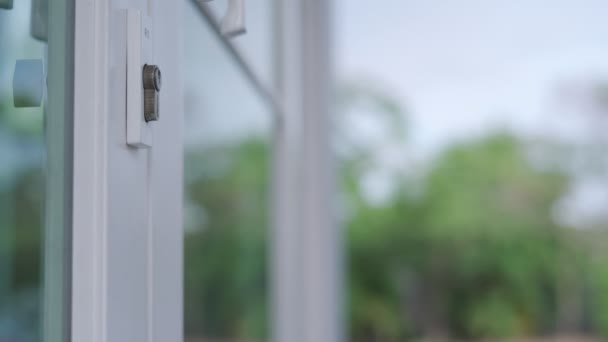 家のコンセプトのための家主 新しい家の鍵を開けるための家の鍵がドアに差し込まれている 木製のキーホルダーが風に吹かれながら動いていた — ストック動画