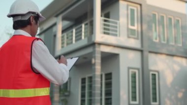 Mühendis evin son teftişini müşteriye teslim etmek için tekrar kontrol etti. Müfettiş müteahhitlerin düzeltmeleri için düzeltme noktası yazıyor. Ev teftiş acentesi konsepti.