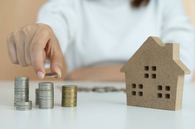 Gelir ve giderleri hesaplamak ve analiz etmek için hesap makinesine basan adamın parmağı ve madeni paraların büyümesi, akıllıca ve ihtiyatlı bir şekilde, yatırım, tasarruf ve borç kavramı