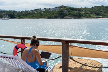 Serbest çalışanlar, 5G internet bağlantısı olan dizüstü bilgisayarlarla çalışıyorlar. Parlak deniz turizmiyle serbest kariyer