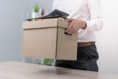 Bir iş adamı bir yöneticiye ya da yöneticiye istifa mektubu gönderdikten sonra kişisel eşyaları için bir kutu tutar. İstifalar, boşluklar ve iş değişiklikleri hakkında bilgi içerir.