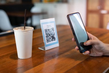 Erkekler, menü seçmek ya da indirim almak için taramak ya da bir kafede yiyecek ve içecek için ödeme yapmak için bir QR kodunu taramak için telefon kullanırlar. Parayı transfer etmek için ya da nakit olmadan internet üzerinden ödeme yapmak için..