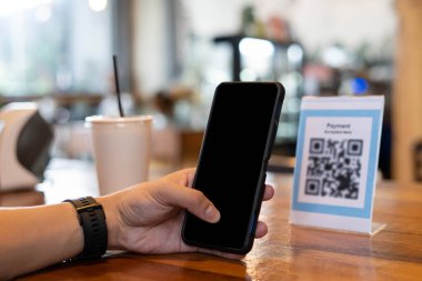 Erkekler, menü seçmek ya da indirim almak için taramak ya da bir kafede yiyecek ve içecek için ödeme yapmak için bir QR kodunu taramak için telefon kullanırlar. Parayı transfer etmek için ya da nakit olmadan internet üzerinden ödeme yapmak için..
