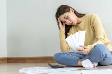 Kadınlar kredi kartı borçları ve yerdeki faturalar yüzünden stres yapıyor. Ev hanımı aylık giderleri hesaplamakta zorlanır ve bütçe borcu ödemek için yeterli değildir.