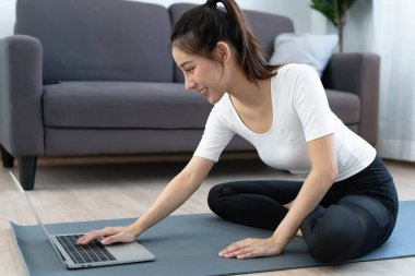 İnternette online video dersleri veren Asyalı kadınlar evde egzersiz yapıyor. Sağlıklı egzersiz fikirleri