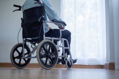 Bacağı sakat bir adam tekerlekli sandalyede oturur. Engelliler odada yalnız ve sinirli oturuyorlardı..