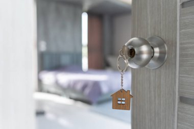 Moving house, relocation. The key was inserted into the door of the new house, inside the room was a cardboard box containing personal belongings and furniture. move in the apartment or condominium