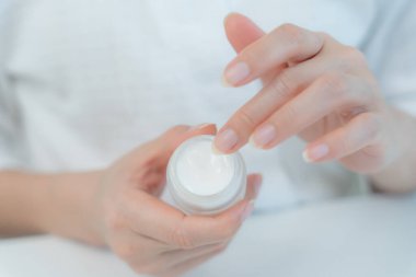 İyi cilt bakım kremi iyi cilt için kullanılır. Sağlıklı bir kadın yüzüne krem sürün ve makyaj yapın. Cilt kremi reklamı, kırışıklık önleyici, bebek yüzü, beyazlatma, nemlendirici.