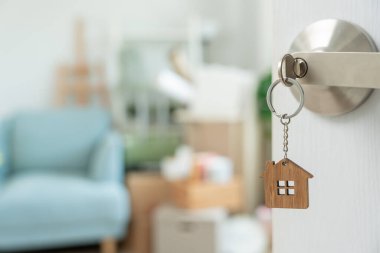 Taşınmak, taşınmak. Anahtar yeni evin kapısına yerleştirilmiş, odanın içinde kişisel eşyalar ve mobilyalar içeren bir karton kutu vardı. Daireye taşın, banne