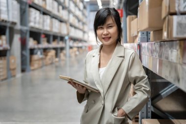 portrait female business owner using digital tablet check amount of stock product inventory on shelf at distribution warehouse factory.logistic business ship and delivery, inventory flow, professional