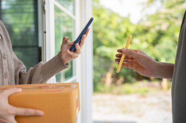 Happy Asian woman scan QR code for pay goods delivery. Delivery man send deliver express. online shop, paper container, takeaway, postman, delivery service, packages, electronic money, Digital transfe