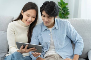 Çift evde online alışveriş yapmak için akıllı telefon kullanıyor. Ödeme detaylarıyla el ele tutuşan cep telefonu sayfa görüntüleme ve kredi kartı, evde kalmak, teknoloji, elektronik ticaret, internet, pazar yeri