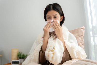 sick woman with a headache sitting under blanket, female sneezing and runny nose with seasonal influenza, allergic, high fever and influenza, resting, virus, coronavirus, feel illness, respiratory