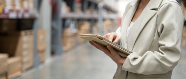 Dijital tablet kullanan bir işletme sahibi dağıtım deposu fabrikasındaki stok ürün envanterini kontrol ediyor. Lojistik iş gemisi ve teslimatı, envanter akışı, profesyonel.