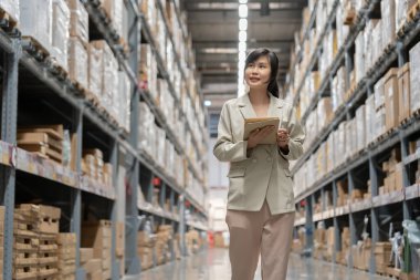 Dijital tablet kullanan bir işletme sahibi dağıtım deposu fabrikasındaki stok ürün envanterini kontrol ediyor. Lojistik iş gemisi ve teslimatı, envanter akışı, profesyonel.