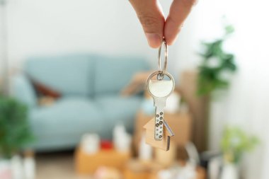 Moving house, relocation. Man hold key house keychain in new apartment. move in new home. Buy or rent real estate. flat tenancy, leasehold property, new landlord, investment, dwelling, loan, mortgage.