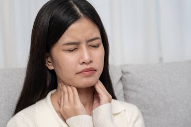 Boğazı ağrıyan bir kadın boynuna takıldı. Dişi bademcik iltihabı iltihaba neden olur. Su alarak, antibiyotik alarak, doktora, virüse, korona virüsüne, gribe, gribe danışarak tedavi olunur.