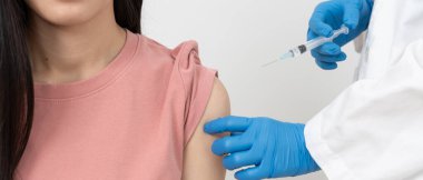 Kadın salgını önlemek için aşı oluyor. Tıp merkezindeki bir hemşire ya da doktordan bir doz bağışıklık aşısı al. Temel aşı, alternatif aşı, riskin artması için aşı.