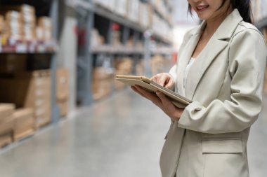 portrait female business owner using digital tablet check amount of stock product inventory on shelf at distribution warehouse factory.logistic business ship and delivery, inventory flow, professional
