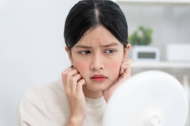 Young woman are worried about faces Dermatology and allergic to steroids in cosmetics. sensitive skin, red face from sunburn, acne, allergic to chemicals, rash on face. skin problems and beauty