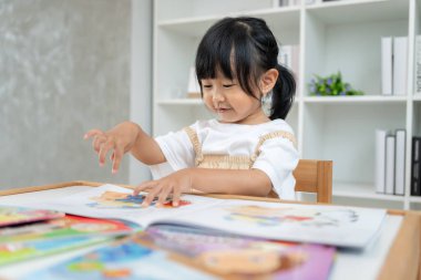 Mutlu Asyalı çocuklar evde kitap okuyarak rahatlar. Kızım ve bir hikaye okuyordum. öğrenme, çocuk bakımı, gülme, eğitim, hikaye anlatma, uygulama, hayal etme, bağımlılık cep telefonunu azaltma