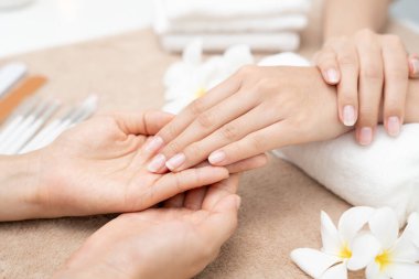 Kadın güzellik merkezinde profesyonel güzellik manikürcüsü tarafından bakım gördükten sonra güzel bir tırnak gösteriyor. Güzellik salonunda jöle tedavisi için tırnak törpüsü kullanın. Manikürcü çok güzel çivi yapıyor..