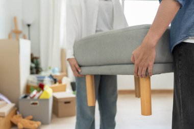 Taşınmak, taşınmak. Birkaç kişi kanepeyi hazırlar ve yeni daire için mobilyaları taşır. Odanın içinde kişisel eşyalar içeren bir karton kutu vardı. yeni daireye ya da daireye taşın