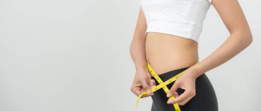 Diyet ve diyet. Güzel, ince kadın vücut ölçüsü. Spor elbiseli bir kadın sağlıklı yaşam için kilo verme hedefine, zayıflığa, ince belliye, beslenme uzmanına ulaşır.