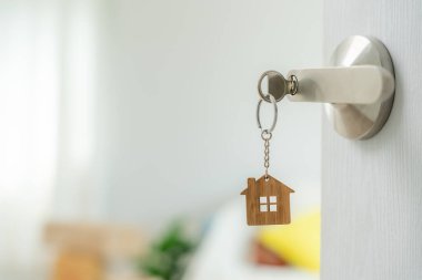 Moving house, relocation. The key was inserted into the door of the new house, inside the room was a cardboard box containing personal belongings and furniture. move in the apartment or condominium