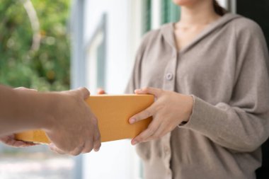 Happy smiling woman receives boxes parcel from courier in front house. Delivery man send deliver express. online shopping, paper containers, takeaway, postman, delivery service, packages