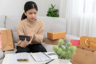 Yüklü faturaları ya da alışveriş faturaları olan stresli Asyalı bir kadın. Masrafları ve kredi kartı borçlarını ödeyecek parası yok. kıtlık, mali sorunlar, ipotek, kredi, yoksul, boş cüzdan, bankacılık