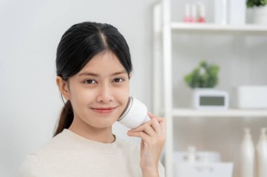 Güzel Asyalı kadınlar gözeneklerini sıkmak için aletler kullanır. Sağlıklı yüzler. Yüz bakımı ve tedavisi. Deri reklamı. Yüz kremi, kırışıklık önleyici, bebek yüzü, beyazlatma, nemlendirici, gözenek sıkılaştırıcı serum.